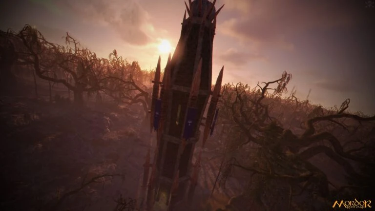 A dark spiked tower against a hazy orange sky, surrounded by bare twisted trees, on the custom Rust map Mordor